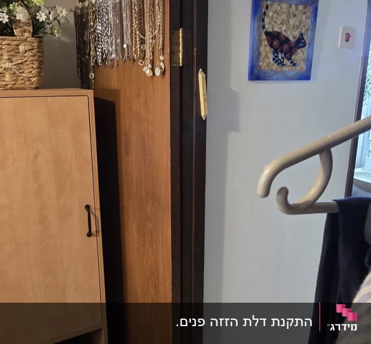 דלת פנים מעץ פתוחה המותקנת בתוך בית מגורים
